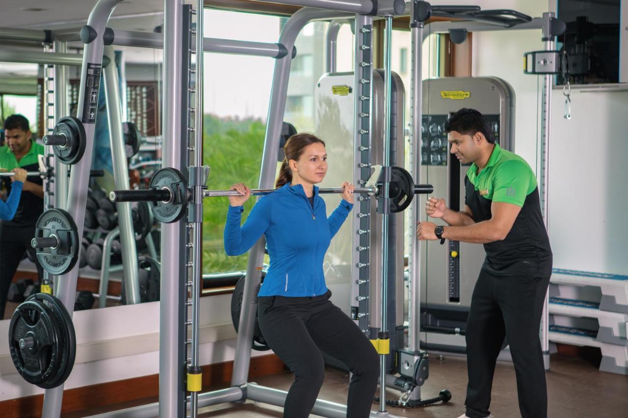 朱美拉梅喜拉海滩酒店及Spa科威特 外观 照片 A personal trainer assisting a woman with a squat