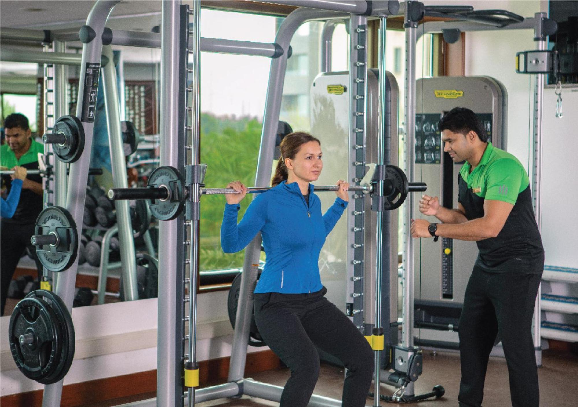 朱美拉梅喜拉海滩酒店及Spa科威特 外观 照片 A personal trainer assisting a woman with a weight training exercise
